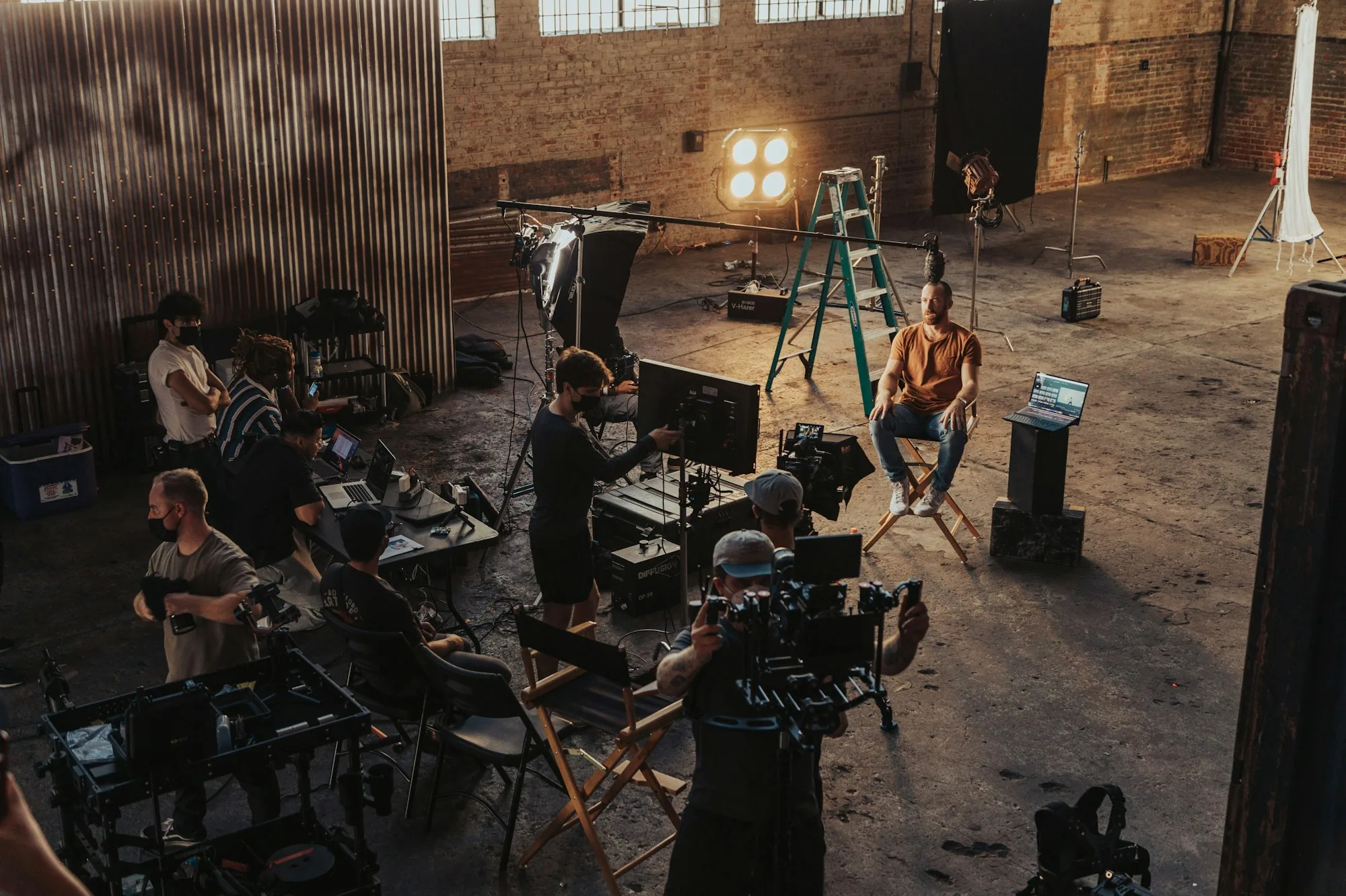 Production crew gathered around a camera setup inside a warehouse studio